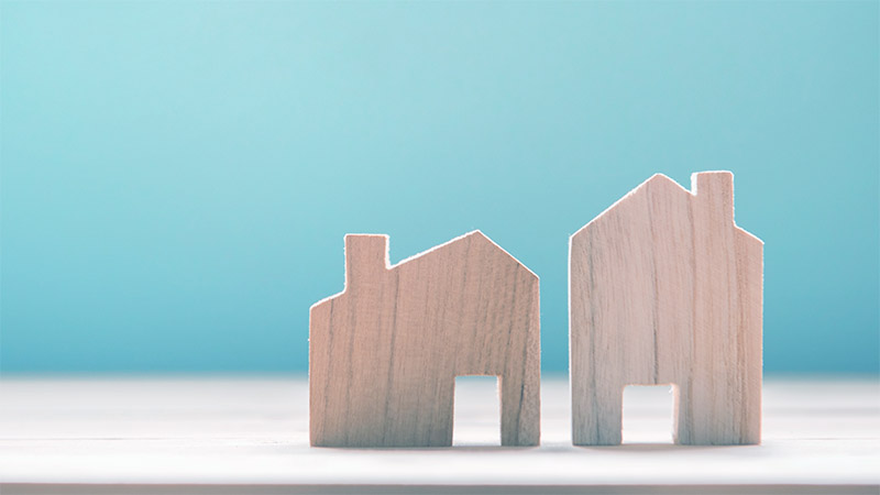 Kleines und grosses Haus nebeneinander: Wer den Gewinn aus dem Verkauf reinvestiert, kann die Grundstückgewinnsteuer aufschieben